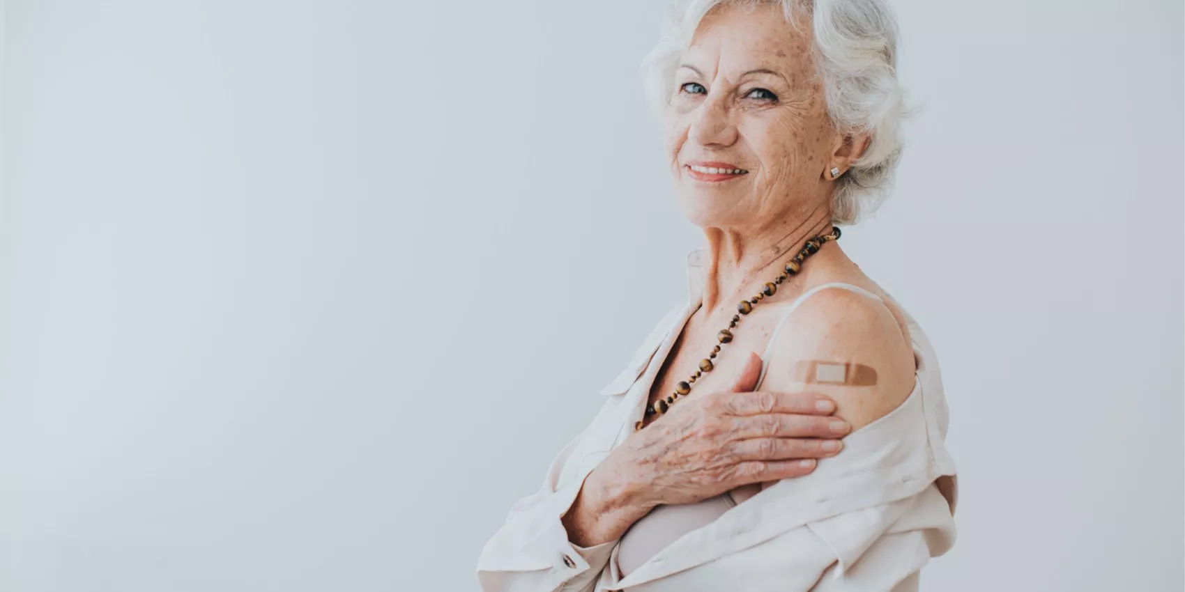 Webinar: Shingles vaccine now in Australia's NIP - Image of woman smiling at the camera with a bandaid over her vaccine site