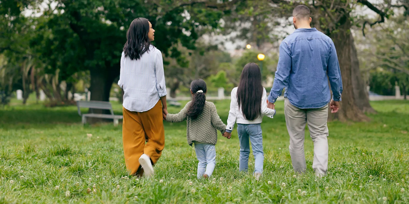 A young family walking away from the camera