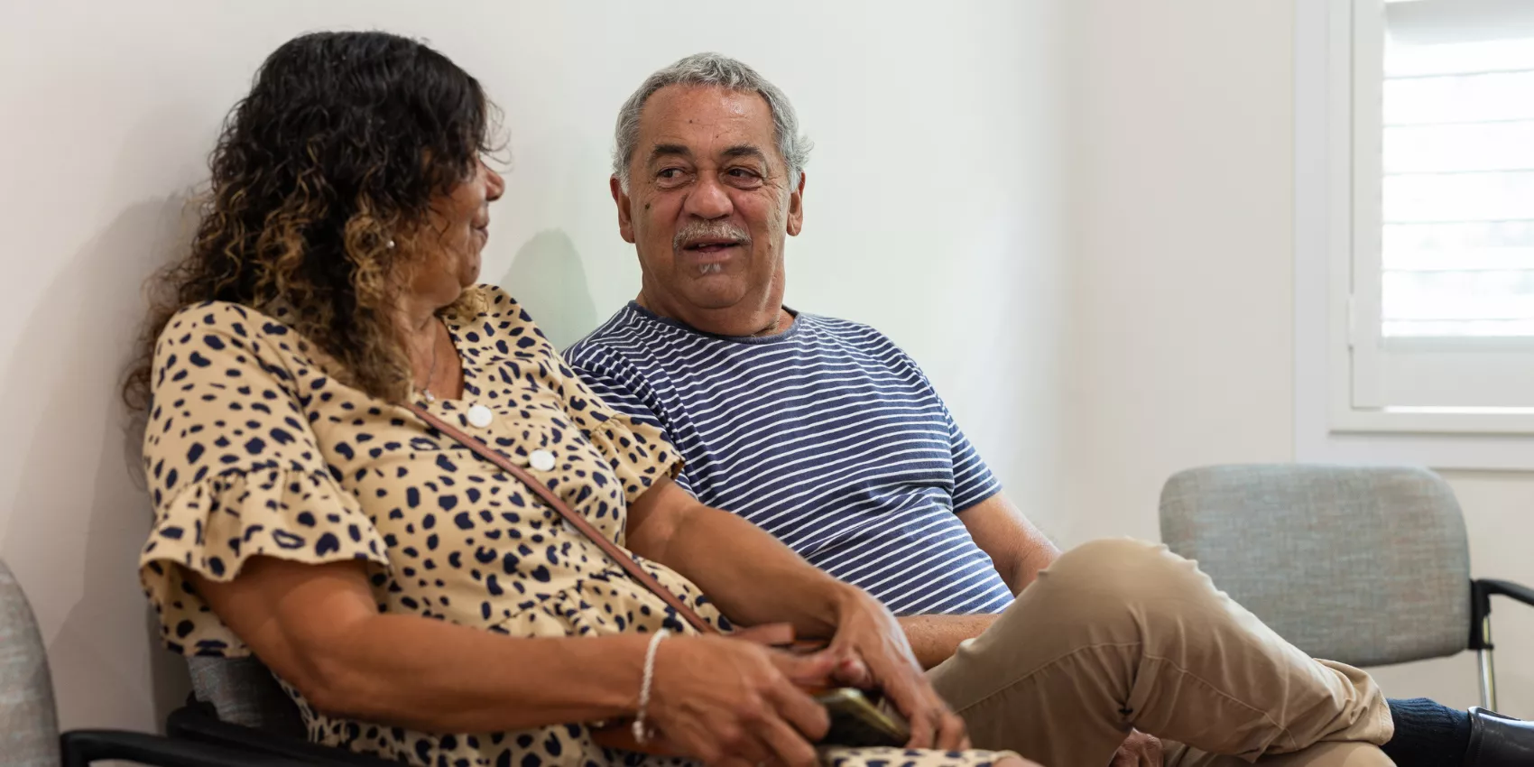 An Aboriginal and Torres Strait Islander couple conversing in a waiting room