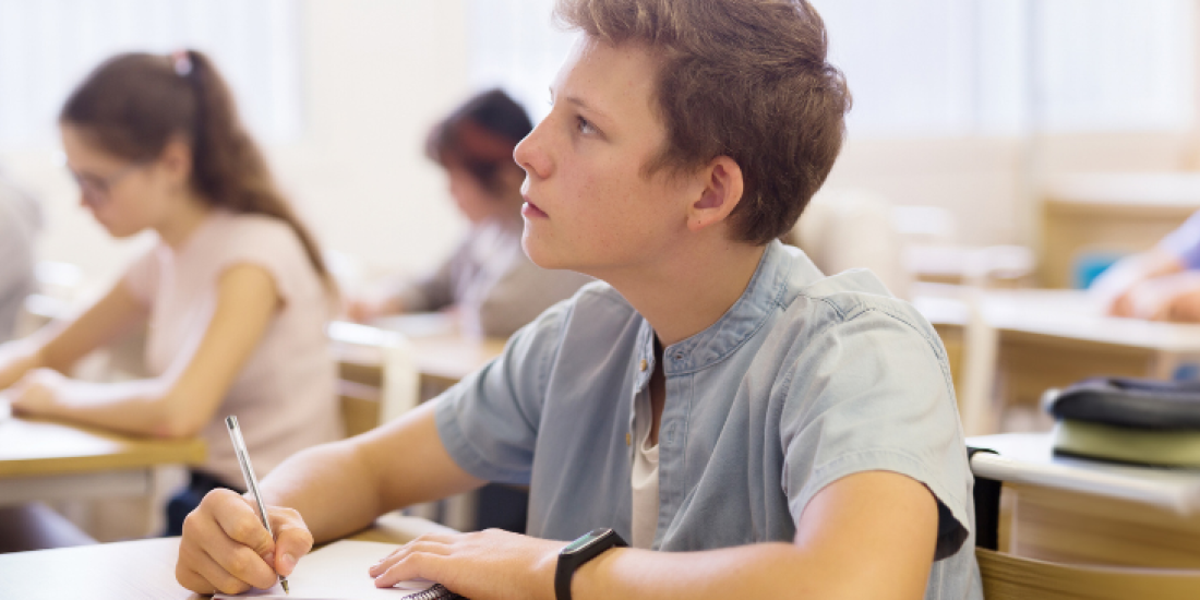 Teenage students at desks in a classroom