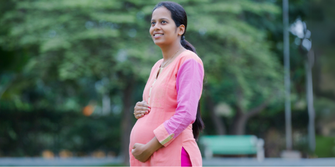 Pregnant woman pictured centred infront of a green background