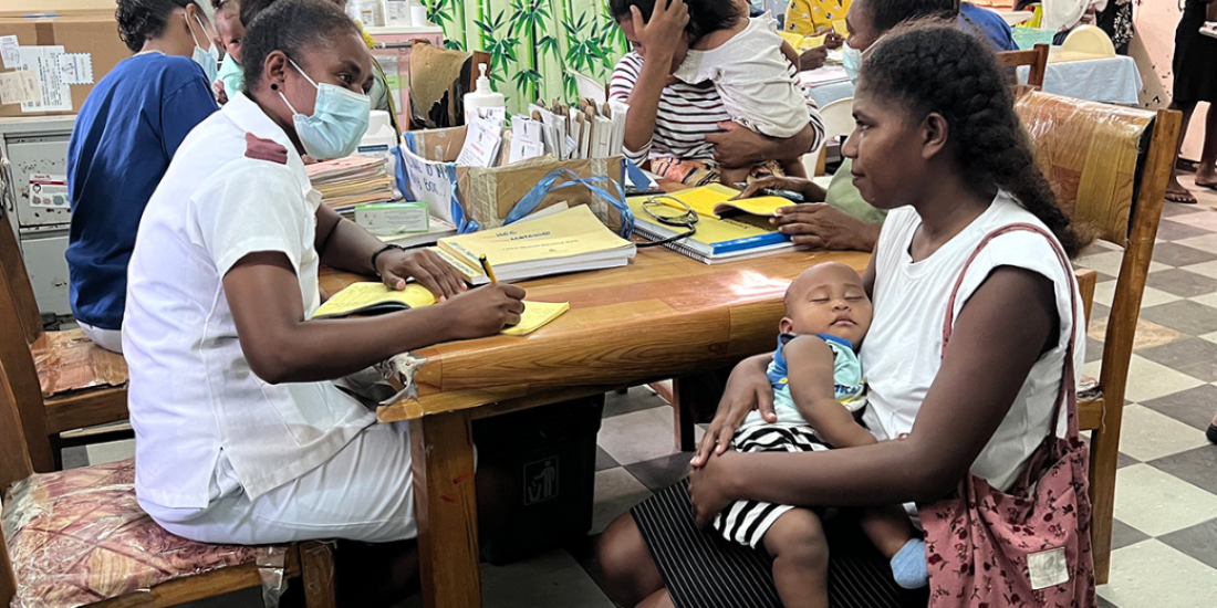 A nurse in Solomon Islands talking to a mother