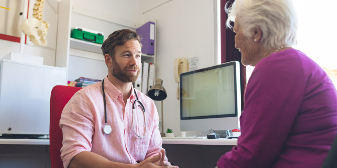 A general practitioner talking with his elderly patient