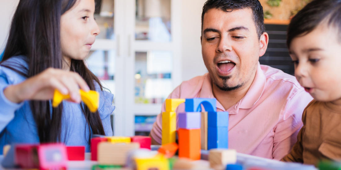 A mother and father playing with building blocks with their young son