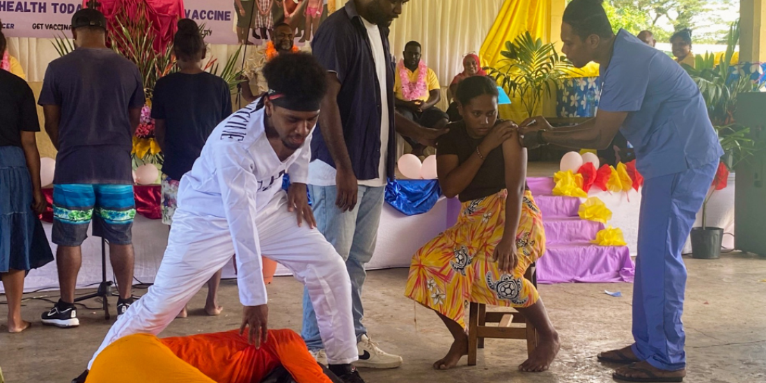 HPV vaccine (in white) defeats HPV virus (in orange) as a girl is immunised by a health worker. The NCIRS-supported pantomime at a rural school in Guadalcanal.