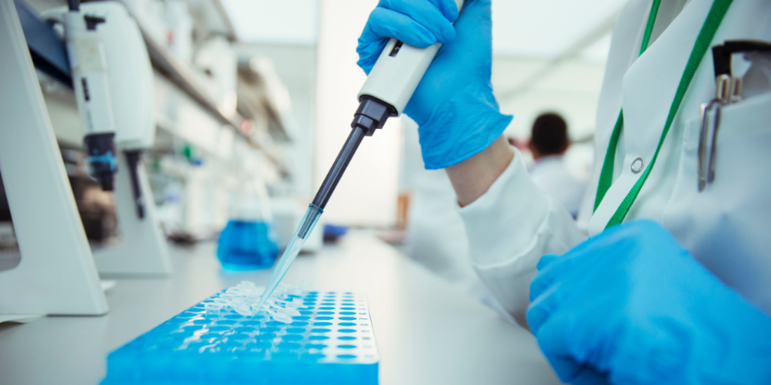 A scientist using a pipette in a laboratory